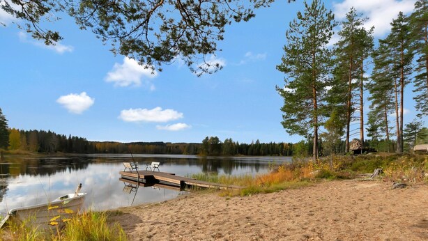 A lakeside setting with a wooden dock, clear skies, and surrounding trees. - Kuusikumpu by Interhome (Petäjävesi)