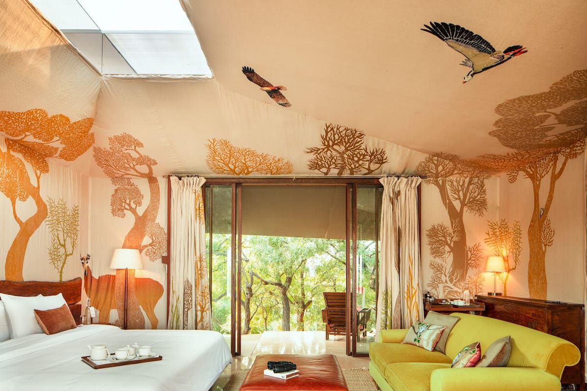 Una habitación con una cama, un sofá, una mesita de café y vistas al exterior.