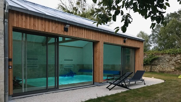 A modern house with a swimming pool, large sliding glass doors, and a patio with lounge chairs. - Gite l'Hermine, 15 pers, heated indoor pool, RDC PMR, enclosed garden (Azay-le-Rideau)