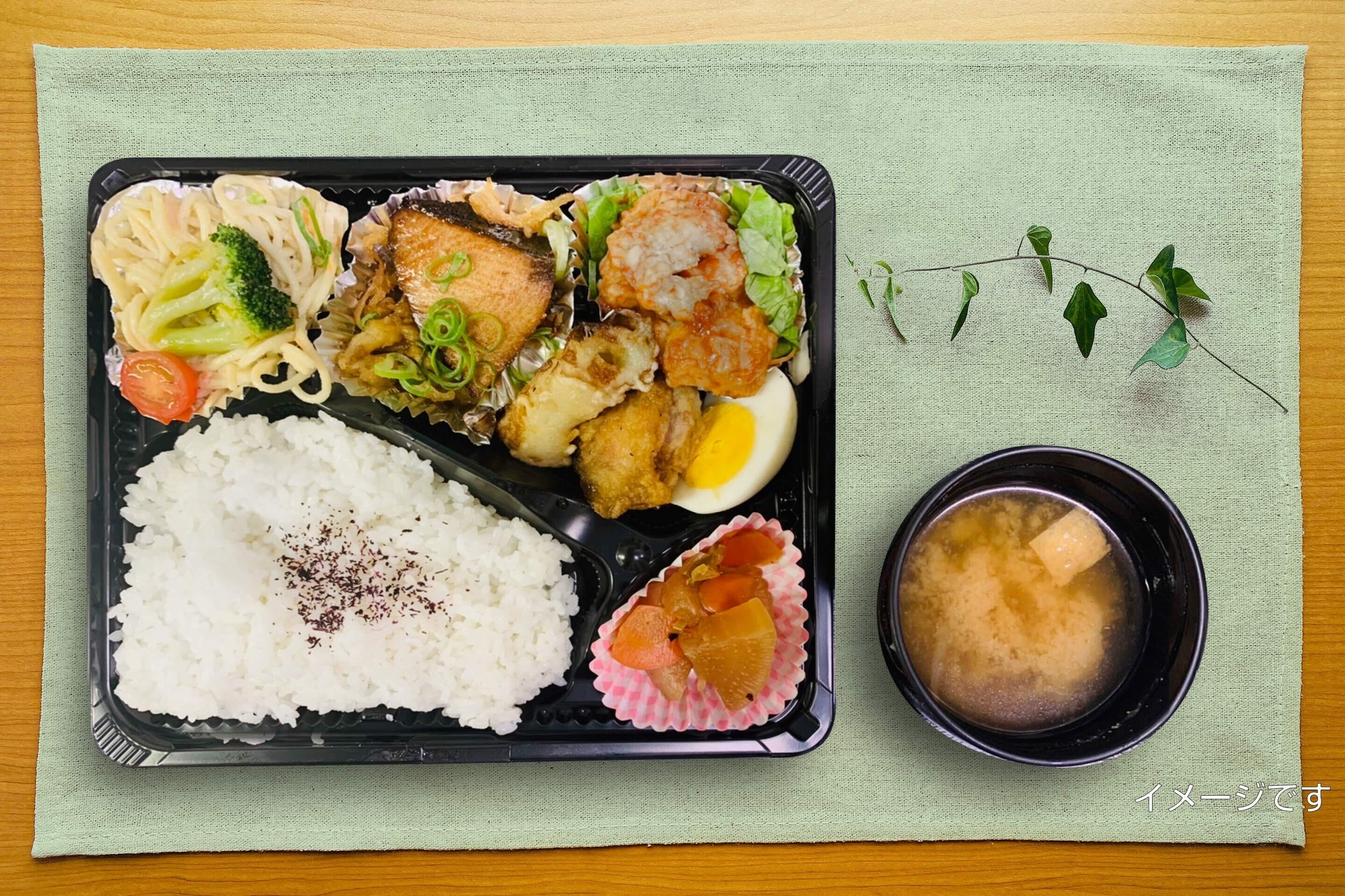 A meal tray with rice, vegetables, and a soup bowl.
