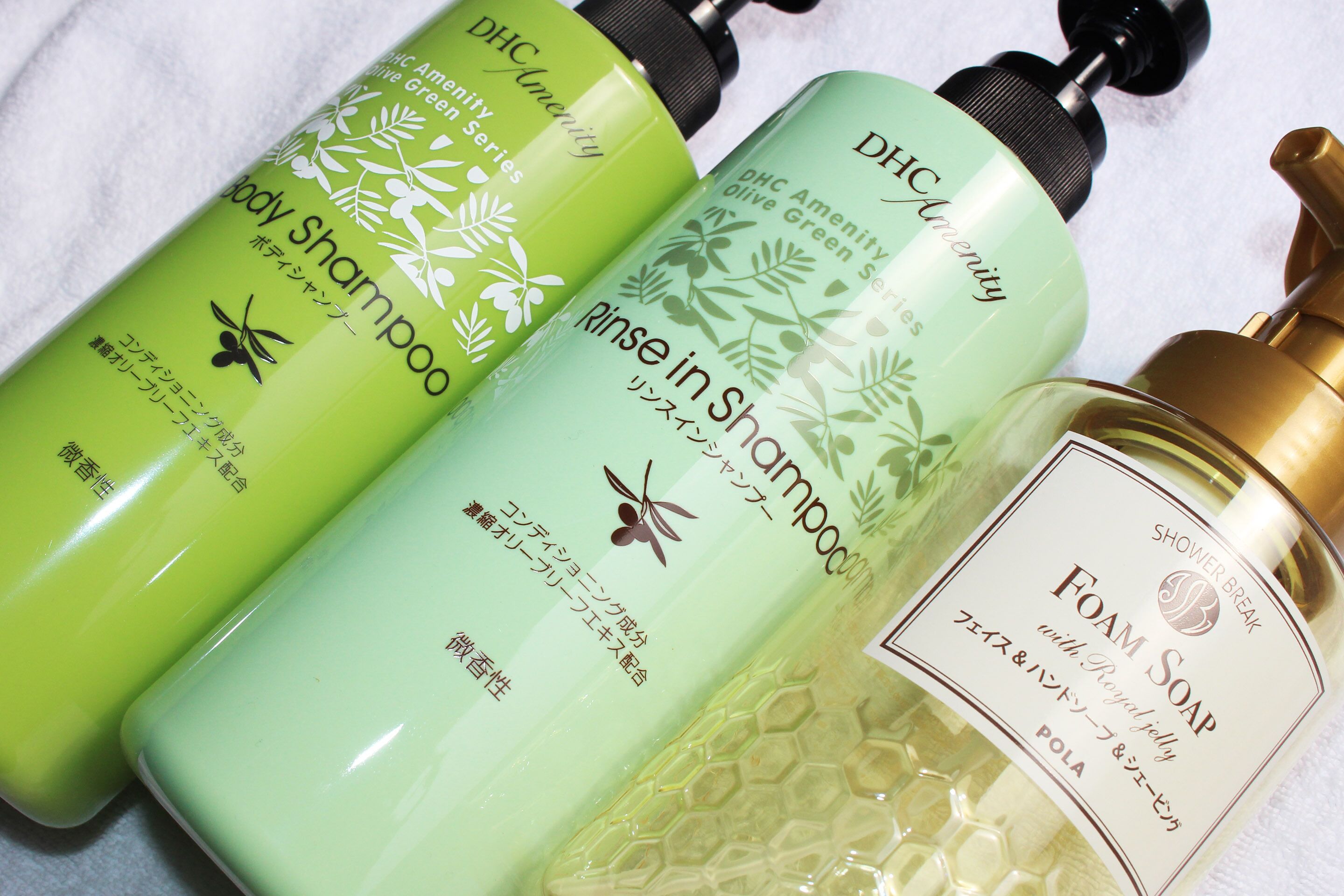 Trois bouteilles de shampoing vert à l’olive de la gamme DHC Amenity et une bouteille de savon moussant de la même gamme.