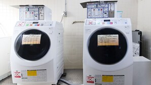 Two front-loading washing machines in a tiled room with control panels on top. - Hotel Sports Palko (Gifu)