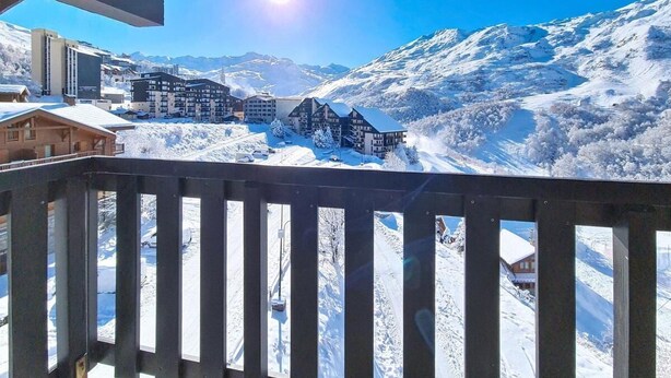 A snowy mountain landscape with buildings and a clear sky.