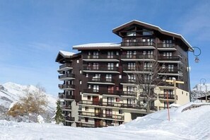 A multi-story hotel with balconies, located in a snowy mountainous area. - 7th floor, balcony, tv, ski locker, 26m², Les Menuires (Les Menuires)