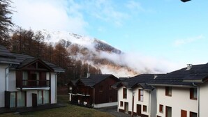 A row of cabins with a mountain in the background.