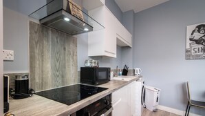 A modern kitchen with a built-in stove, microwave, and white cabinets. - Arena Apartments (Nottingham)