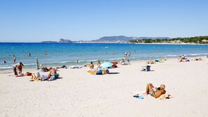A beach with people sunbathing and swimming, a clear sky, and distant mountains. - Superb luxury villa rental with heated pool (Le Castellet)