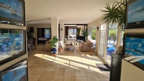 A spacious living area with a large TV, comfortable seating, and a view of the outdoors. - Superb luxury villa rental with heated pool (Le Castellet)