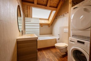 A compact bathroom with a skylight, a sink, a toilet, and a stacked washer and dryer. - 350m from shops, 1st floor, fitness, sauna, hammam, balcony, fireplace or stove, ski locker, 55m² (Valloire)