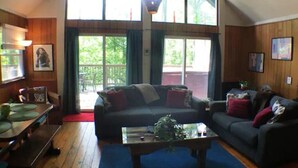 A spacious loft with high ceilings, large windows, and a cozy seating area with a sofa and coffee table.