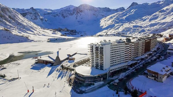 A snow-covered mountain resort with a large hotel and a heliport. - 200m from ski slopes, 1st floor, view lake, terrace, tv, 50m², Tignes (Tignes)