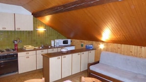 Eine kleine Küche mit Holzausstattung, einer Mikrowelle und einem Radio.