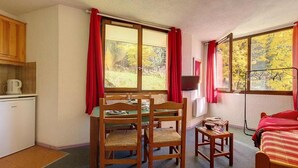 A compact room with a dining table and chairs, a small kitchen area, and a bed. - 5th floor, tv, ski locker, 22m², Les Menuires (Les Menuires)