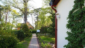 A paved pathway leading to a building with a red pipe and a white wall. - Apartment 2 - Us Klausing (Heringsdorf)