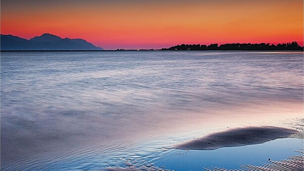 A calm body of water reflecting a sunset with mountains in the background. - 3 bedroom stunning apartment in Rogotin (Rogotin)