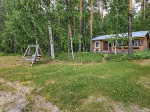 A wooden cabin with a porch, surrounded by a forest. - Koivuranta by Interhome (Savonlinna)