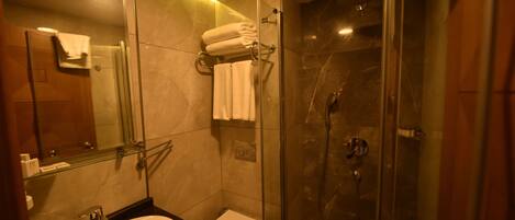 Une salle de bain moderne avec une douche à parois de verre, un lavabo et des toilettes.