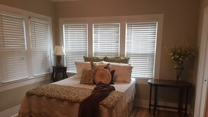 A bedroom with a bed, bedside tables, a lamp, and a window with blinds. - Back to School Special! 5 minutes from Majestic Baseball Fields (Hot Springs)