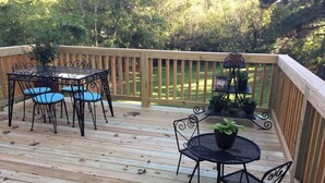 A wooden deck with a table and chairs, surrounded by a wooden railing. - Back to School Special! 5 minutes from Majestic Baseball Fields (Hot Springs)