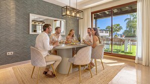 A dining area with a round table, four chairs, and a view of the outdoors. - RELISH THIS TOP NOTCH, GENEROUS DUPLEX WITH HEATED POOL IN PRIVATE SOLARIUM (Nueva Andalucía)
