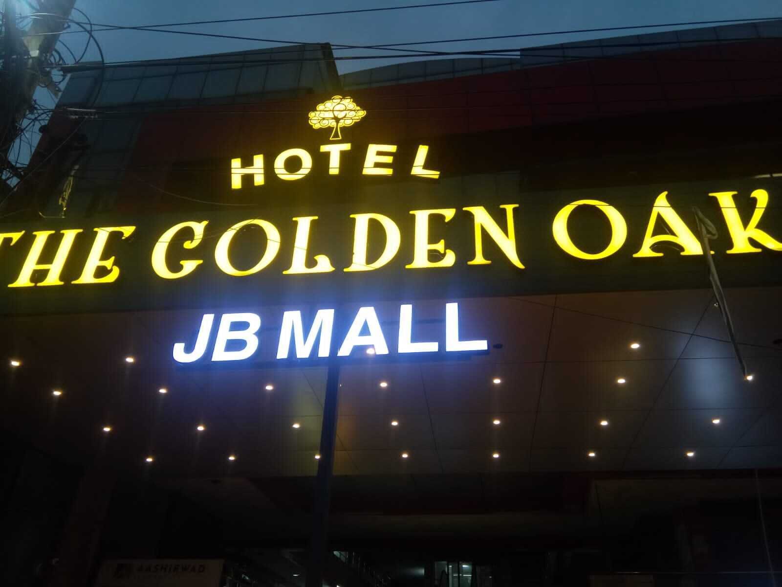 A hotel sign with the name "The Golden Oak" and "JB Mall" indicating its location.