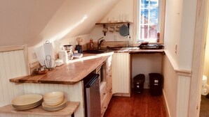 A compact kitchen with wooden countertops, a built-in oven, and a window providing natural light. - Newly built quiet studio apartment near Reversing Falls (Blue Hill)