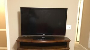 Un televisor de pantalla plana sobre un mueble de madera con chimenea integrada.