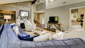 A living room with a fireplace, a television, and a sofa. - Four Bedroom Sea Pines Home with Private Pool ~ 5 Minute Walk to the Beach! (Hilton Head Island)