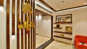Un interior moderno con un separador de madera, un sofá rojo y decoración en la pared.