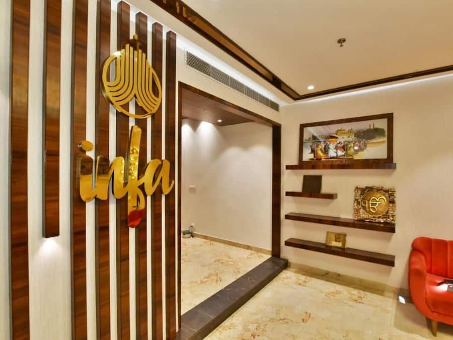 Un interior moderno con un separador de madera, un sofá rojo y decoración en la pared.