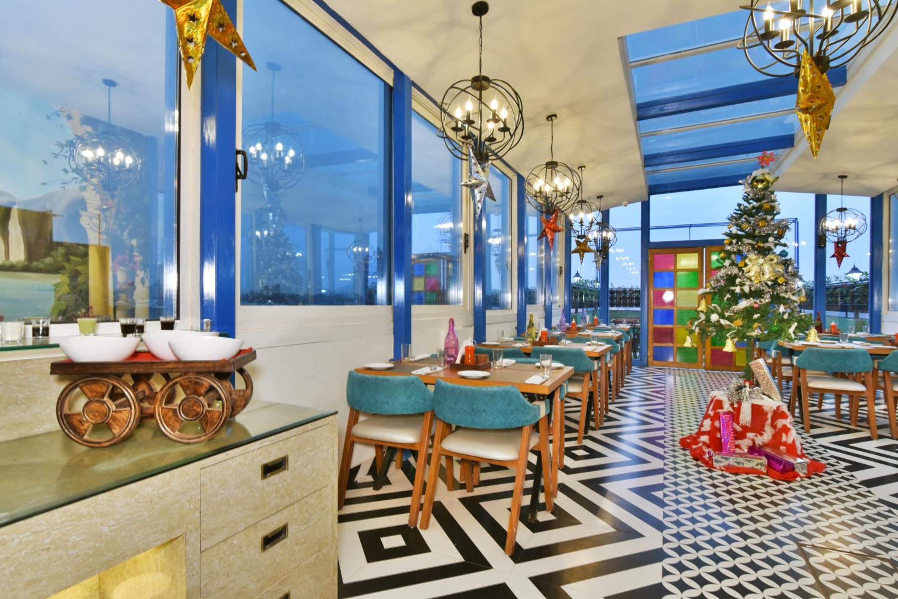 Un restaurante moderno con ventanas amplias, un árbol de Navidad y un diseño de techo singular.