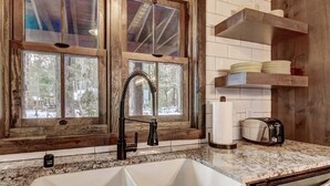 A kitchen with a double sink, wooden window frames, and a countertop with a toaster. - Heavenly Hideaway 4BR,4BA, Hot Tub (South Lake Tahoe)
