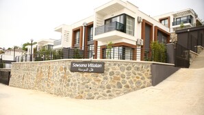 A modern villa with a stone facade, a balcony, and a sign indicating the name 'Sawsana Villari'. - Sawsana Villalari (Sapanca)