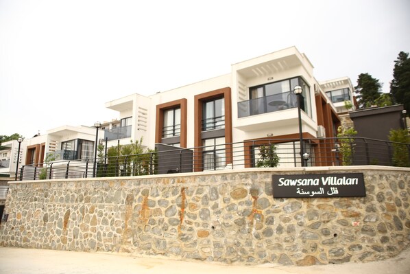 A modern building with a stone facade and a sign reading "Sawsana Villalani".