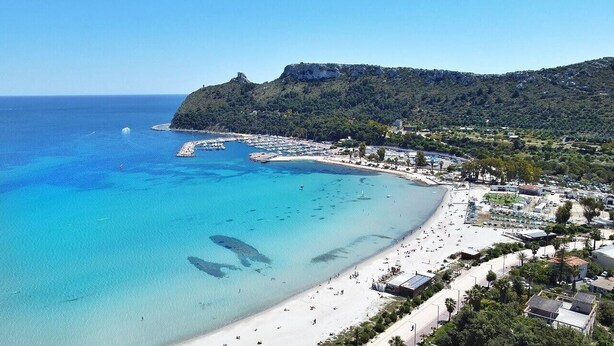 A coastal town with a beach, clear blue waters, and a mountainous backdrop. - Meigama, modern loft in historic center of Cagliari (Cagliari)