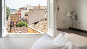 A hotel room with a view of a cityscape through a window. - Meigama, modern loft in historic center of Cagliari (Cagliari)