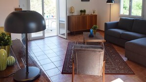 A living room with a sofa, a coffee table, a lamp, and a cabinet. There is a door leading to a balcony. - Hillside Villa with Pool, Joyeuse (Joyeuse)