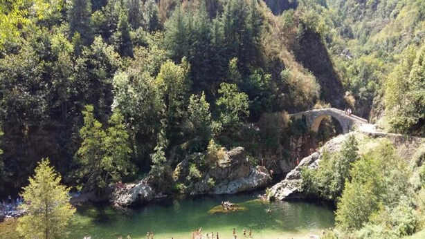 A natural setting with a river, a stone bridge, and a crowded beach area. - Hillside Villa with Pool, Joyeuse (Joyeuse)