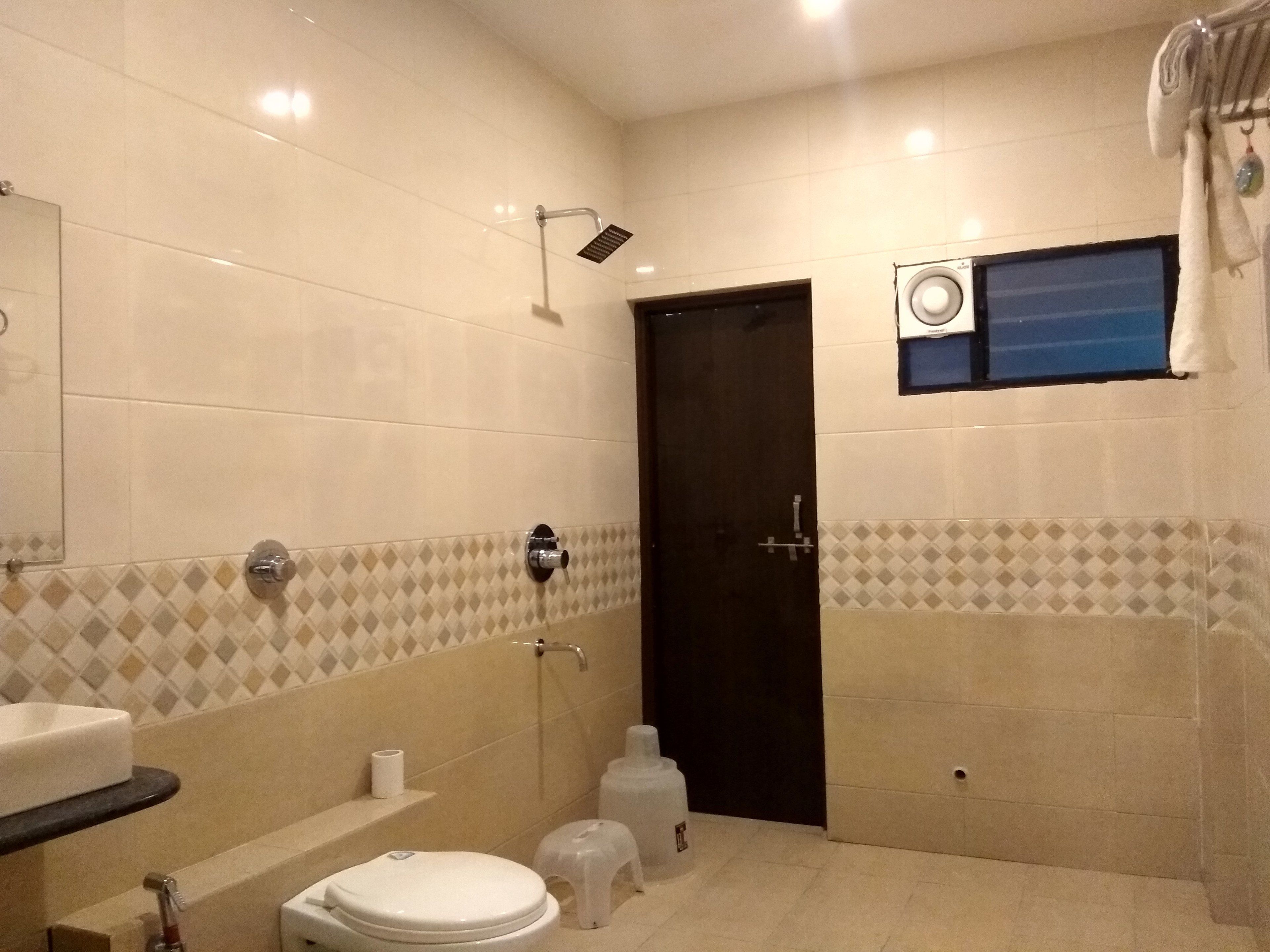 Baño con inodoro, lavabo, ducha y ventana.