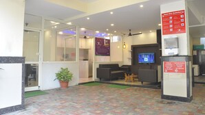 A hotel lobby with a reception desk, seating area, and a television screen. - JK Rooms 126 Parashar Legacy - Station (Nagpur)