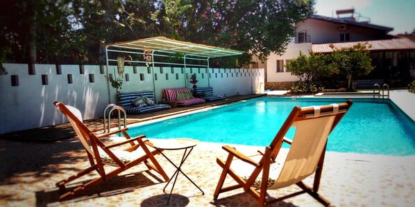 A swimming pool with lounge chairs and a covered seating area. - Dalyan Holiday Hotel (Ortaca)