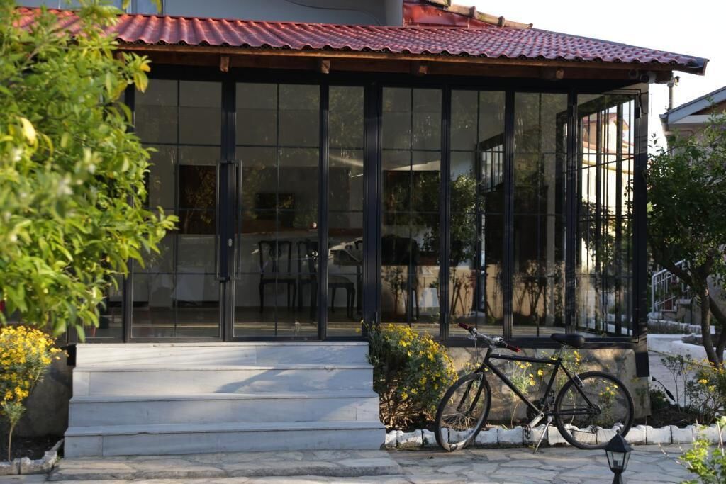 Ein Gebäude mit Glasfassade, ein Fahrrad vor der Tür und ein rotes Dach.