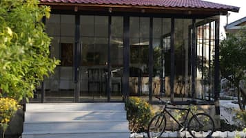 Un edificio con fachada de vidrio, una bicicleta estacionada afuera y un techo rojo.