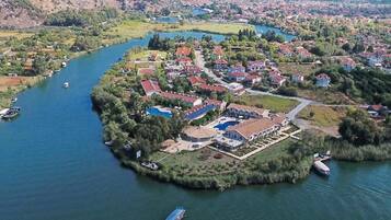 Zona residencial a orillas del río con casas, piscina y barcos.