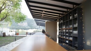 An outdoor bar area with a long counter, a metal ceiling, and shelves with glassware. - Dalyan Holiday Hotel (Ortaca)