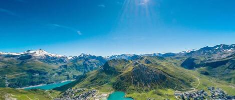 A mountainous landscape with a lake and a small settlement.