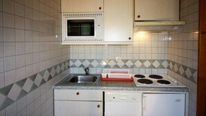 Una cocina compacta equipada con microondas, estufa, fregadero y lavavajillas.