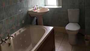 Un baño con bañera, lavabo e inodoro.