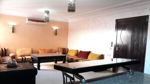 A modern living room with a sofa, coffee table, and a dining table. - Charming little studio in Marrakech 4095 (Marrakech)