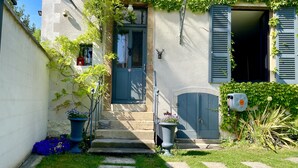 A quaint house with a blue door, a small porch, and steps leading to the entrance. - Mon Coeur House and Garden designed by Stay in Beaune is a unique property  (Beaune)